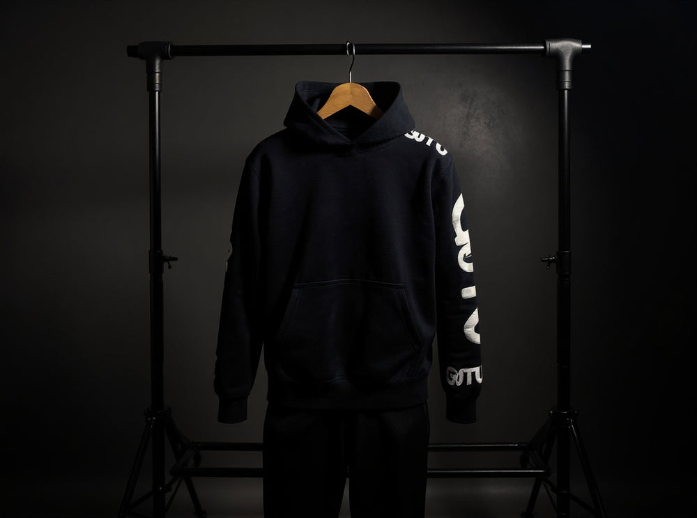 Front view of the black Initial State hoodie with white Gotu sleeve graphics