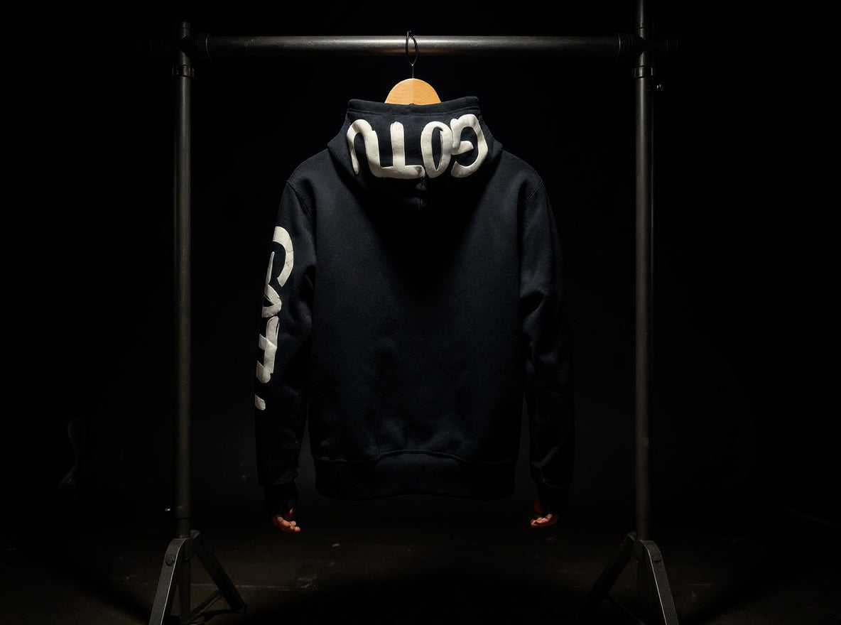Back view of the black Initial State hoodie with white Gotu hood and sleeve lettering